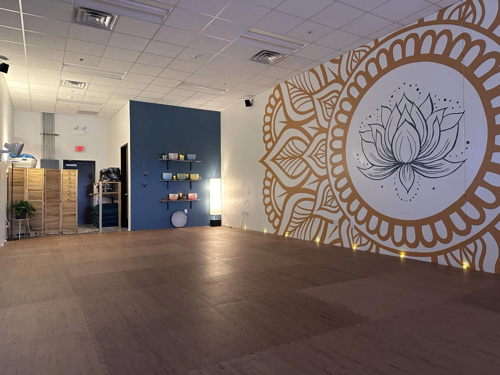 The practice room at Soul Strong Yoga in Hutto, with singing bowls and the lotus mural
